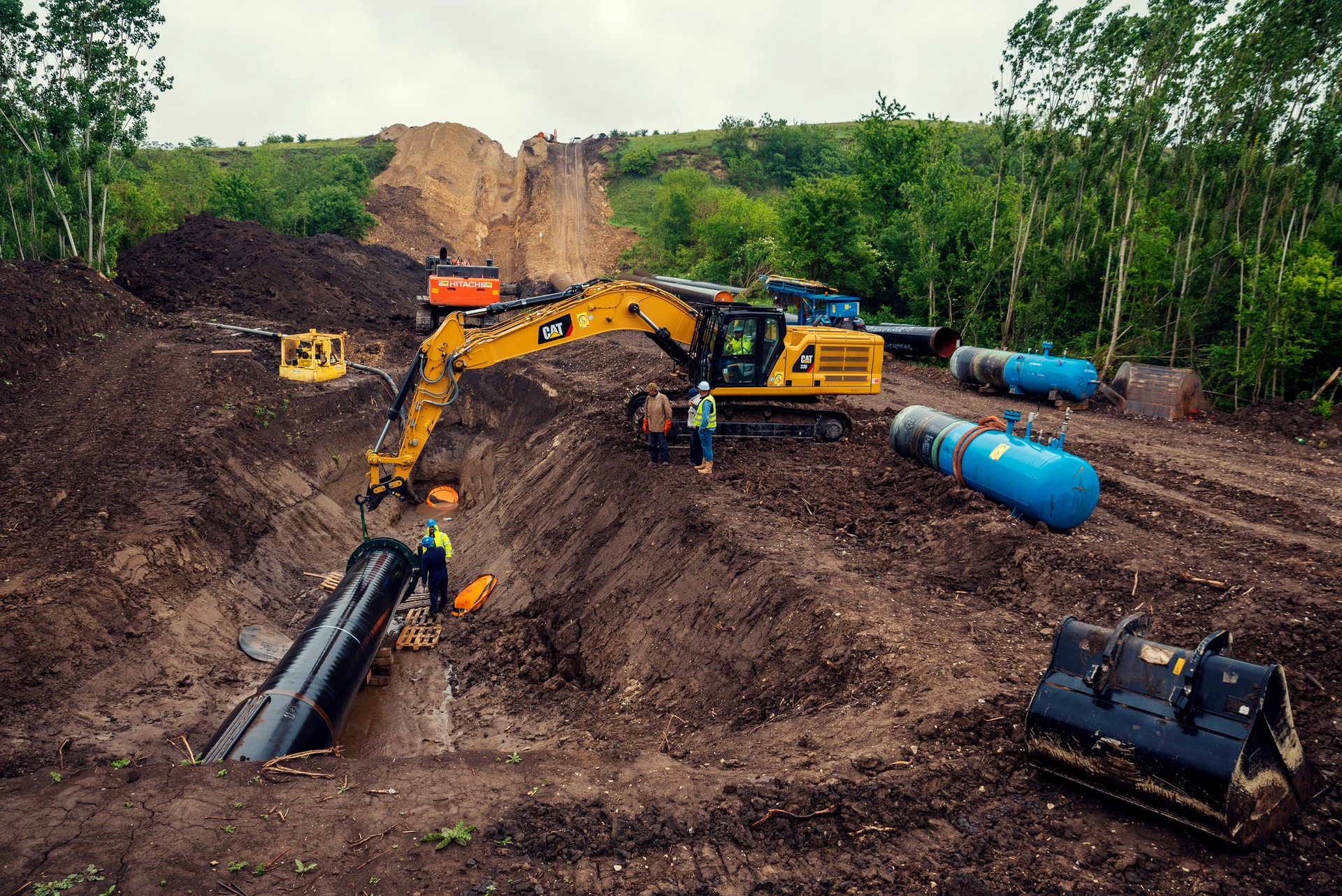 One chain excavators laying pipe in a trench